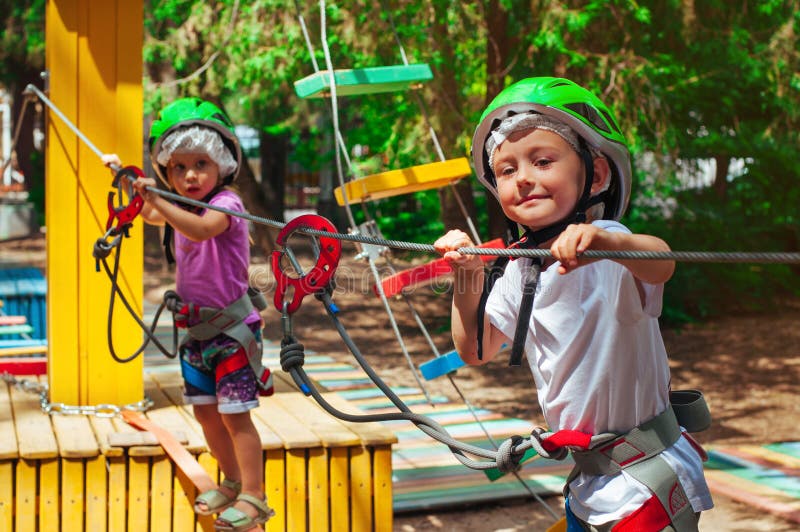Enfants explorant un parc de corde d'aventure extérieur images stock Enfants explorant un parc de corde d'aventure extérieur images stock