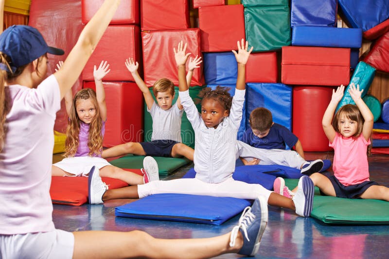 Enfants faisant la gymnastique d'enfants dans le gymnase