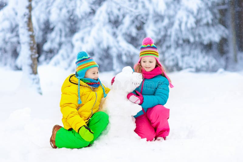 Enfants faisant le bonhomme de neige d'hiver Jeu d'enfants dans la neige photos libres de droits Enfants faisant le bonhomme de neige d'hiver Jeu d'enfants dans la neige photos libres de droits