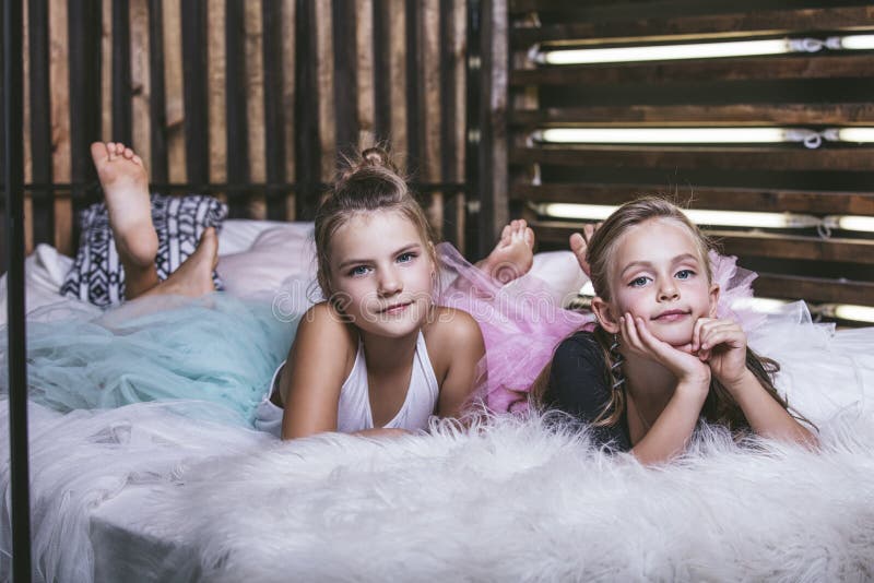 Enfants filles sur le lit dans une jupe de berceau comme une confiture photos libres de droits Enfants filles sur le lit dans une jupe de berceau comme une confiture photos libres de droits