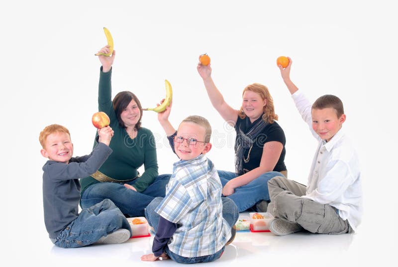 Five happy children, two teenage girls and tree boys sticking up healthy fruit. White background. Five happy children, two teenage girls and tree boys sticking up healthy fruit. White background.
