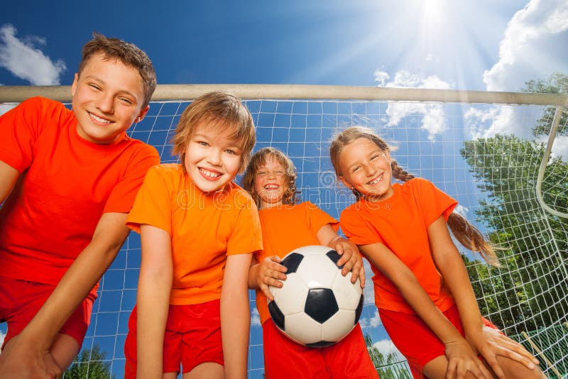 Enfants heureux avec la vue du football de dessous images stock Enfants heureux avec la vue du football de dessous images stock