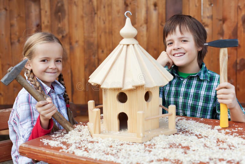 Enfants heureux construisant une maison d'oiseau Enfants heureux construisant une maison d'oiseau