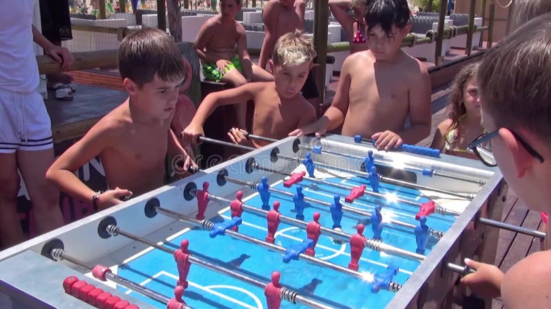 Enfants jouant au baby-foot sur la plage. amuser.