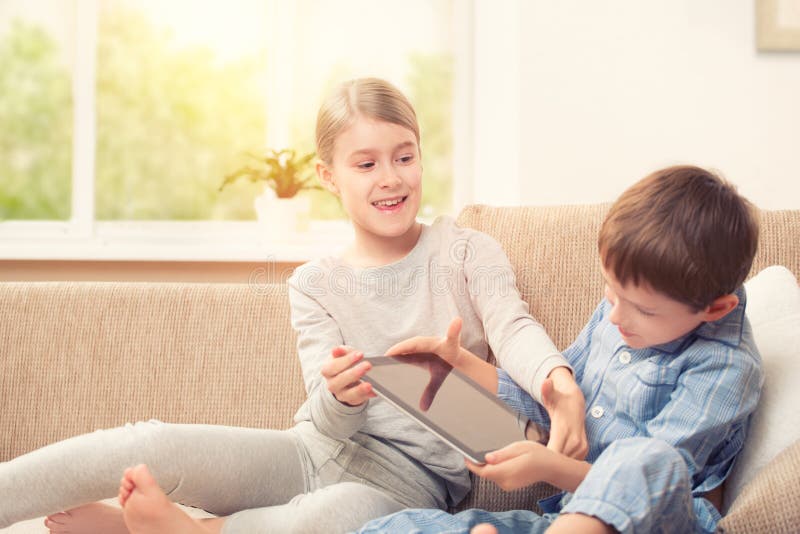 Enfants jouant avec le comprimé numérique photographie stock libre de droits Enfants jouant avec le comprimé numérique photographie stock libre de droits