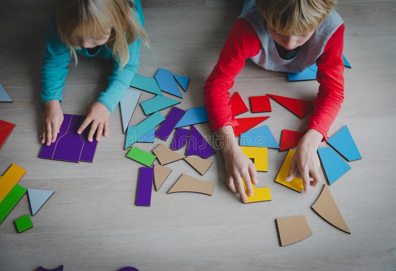 Enfants jouant avec le puzzle ou le tangram, concept d'éducation photos stock Enfants jouant avec le puzzle ou le tangram, concept d'éducation photos stock