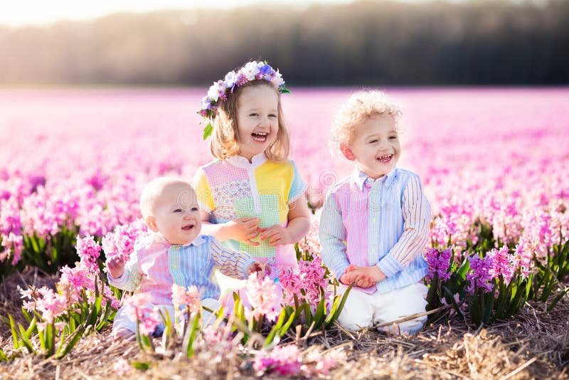Enfants jouant dans le domaine de fleur image stock Enfants jouant dans le domaine de fleur image stock