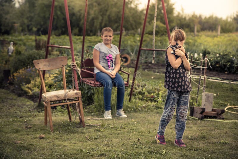 Enfants jouant dehors le mode de vie de campagne de terrain de jeu d'arrière-cour pendant des vacances d'été dans les enfants heu photos libres de droits Enfants jouant dehors le mode de vie de campagne de terrain de jeu d'arrière-cour pendant des vacances d'été dans les enfants heu photos libres de droits