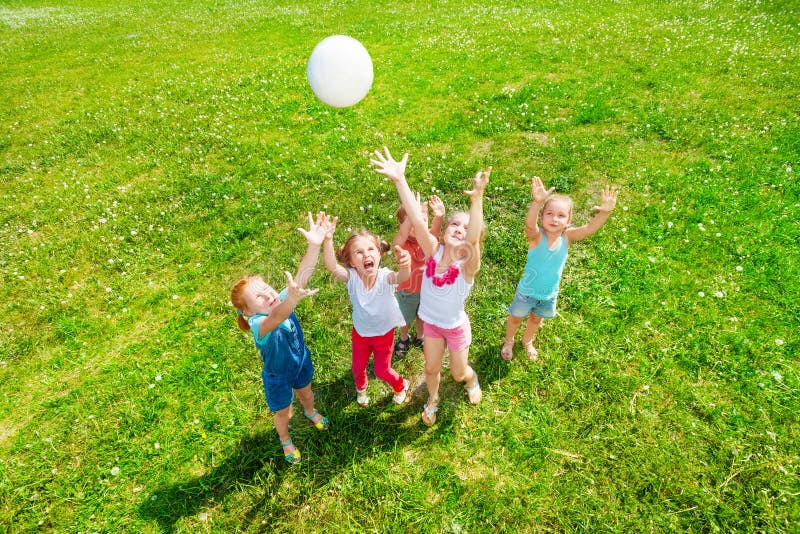 Five kids playing ball on a dandelion meadow. Five kids playing ball on a dandelion meadow.