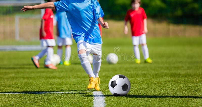 Enfants jouant le jeu de football du football sur le champ de sports photo stock Enfants jouant le jeu de football du football sur le champ de sports photo stock