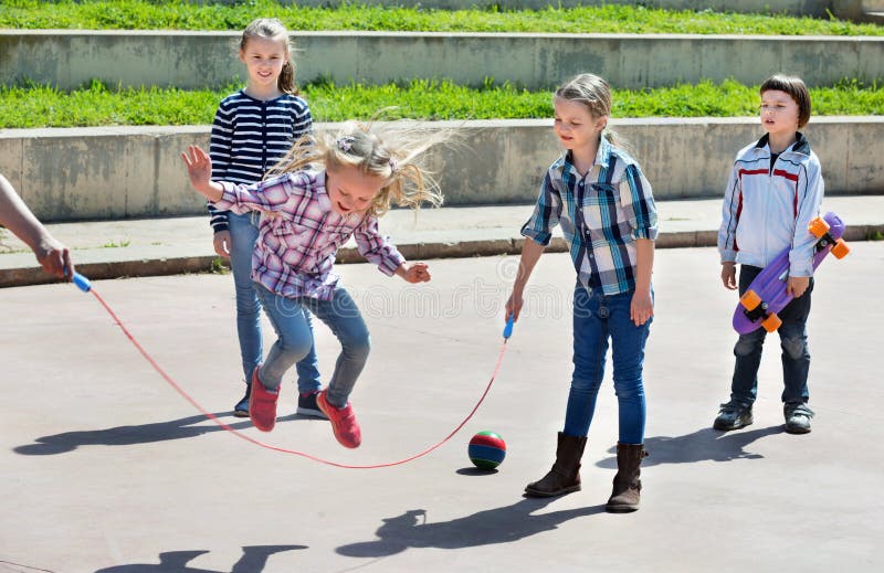 Enfants Jouant Le Jeu Sautant De Corde à Sauter Image stock