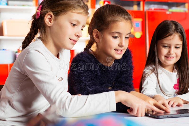 Enfants jouant sur la tablette images stock Enfants jouant sur la tablette images stock