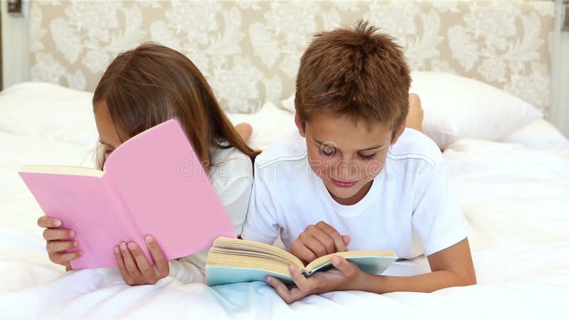 Enfants lisant un livre sur le lit