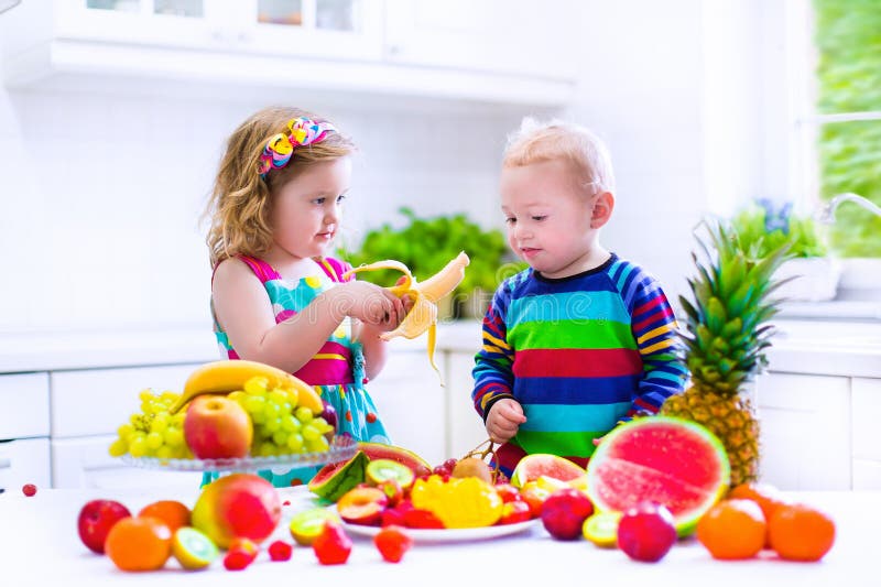 Enfants Mangeant Du Fruit Dans Une Cuisine Blanche Photo stock Image