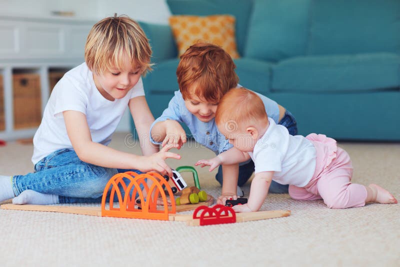 Enfants mignons, enfants de m?mes parents jouant des jouets ensemble sur le tapis ? la maison image libre de droits Enfants mignons, enfants de m?mes parents jouant des jouets ensemble sur le tapis ? la maison image libre de droits