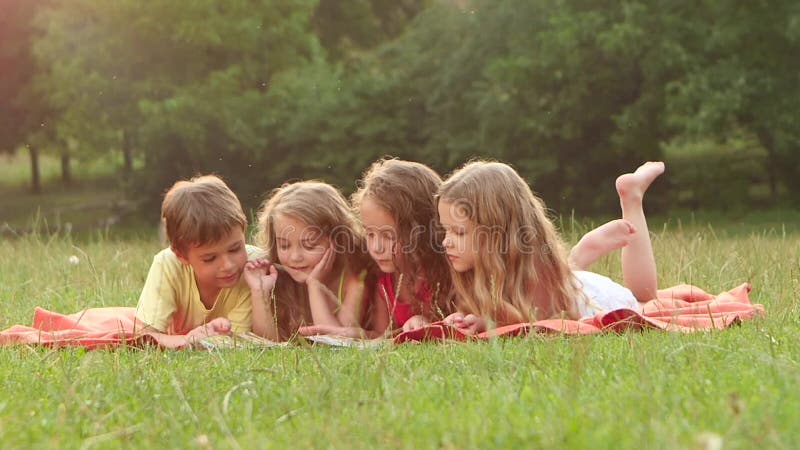 Enfants mignons lisant un livre pendant l'été de jardin ensemble par beau jour Mouvement lent Fin vers le haut