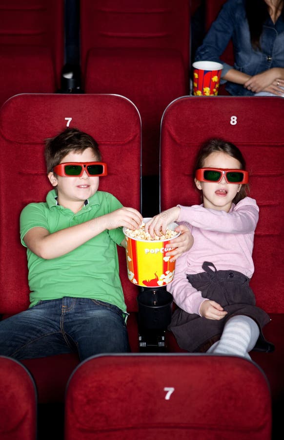 Children sharing popcorn in the 3D movie theater. Children sharing popcorn in the 3D movie theater