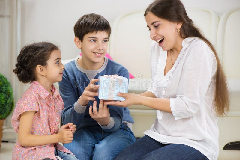 Enfants présent un cadeau à la mère photographie stock libre de droits Enfants présent un cadeau à la mère photographie stock libre de droits