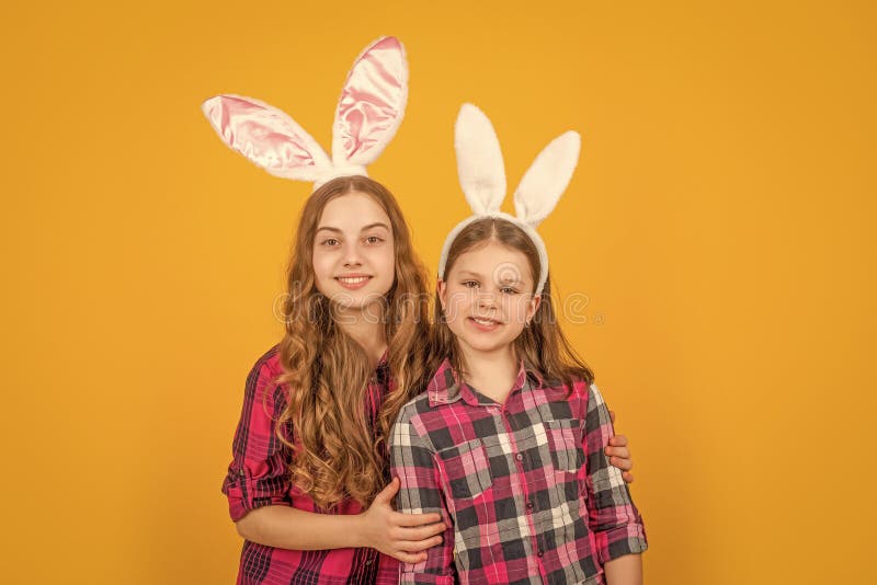Enfants pâques joyeux dans des oreilles de lapin sur fond jaune images stock