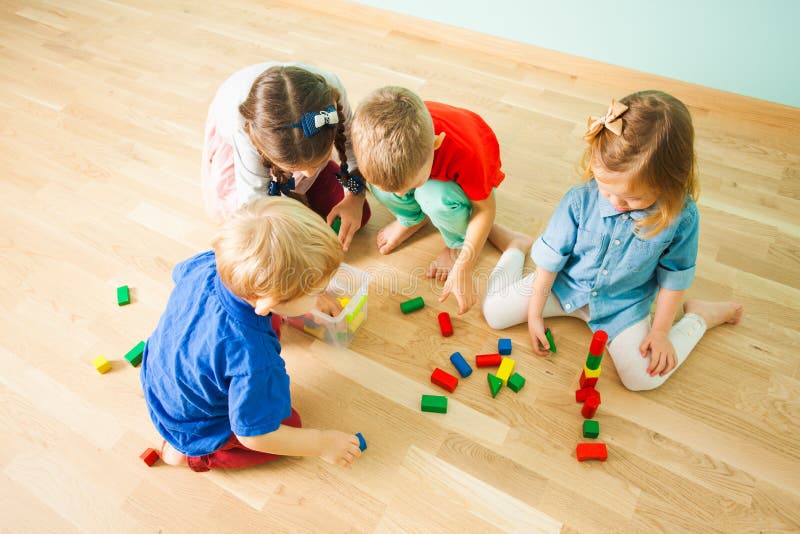 Enfants rassemblant des jouets après le jeu au jardin d'enfants photos stock Enfants rassemblant des jouets après le jeu au jardin d'enfants photos stock
