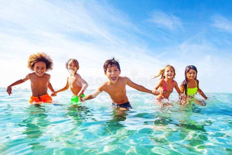 Enfants riant et jouant dans l'eau au bord de la mer