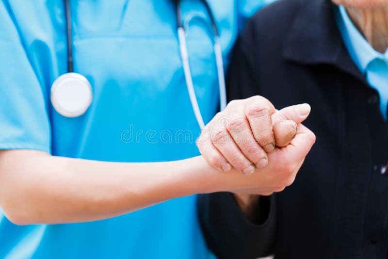 Enfermeira de inquietação que guardara as mãos idosas
