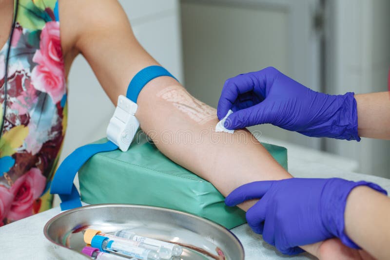 Enfermera que prepara al paciente para hacer un análisis de la sangre con el dispositivo del espectador de las venas fotos de archivo Enfermera que prepara al paciente para hacer un análisis de la sangre con el dispositivo del espectador de las venas fotos de archivo