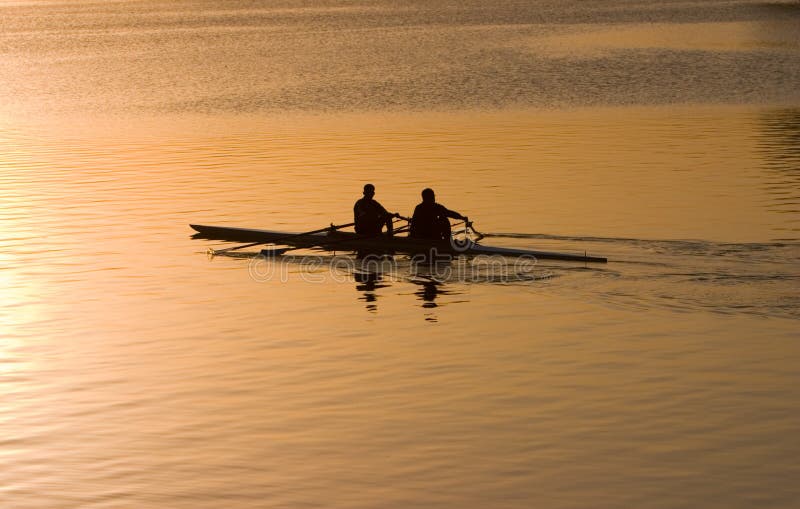 Silhouette of people rowing a boat at sunrise. Silhouette of people rowing a boat at sunrise.