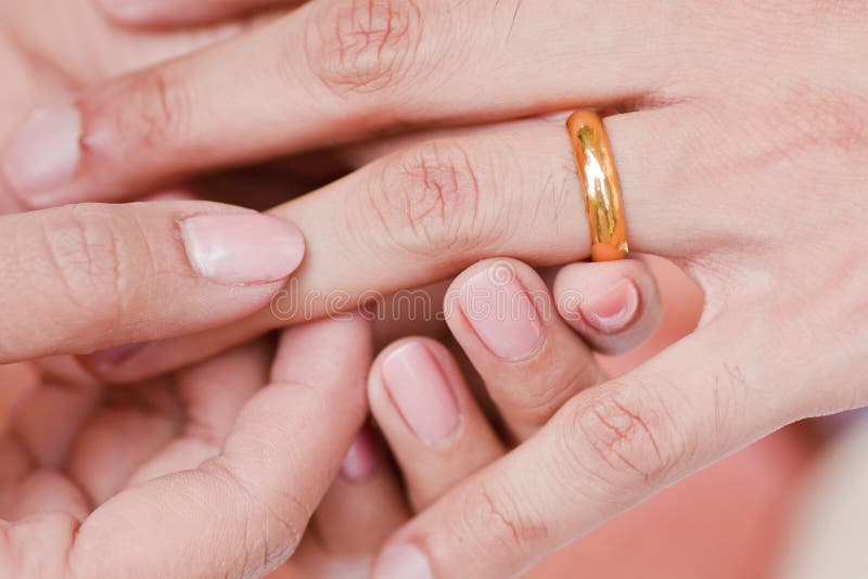 Young Adult Male Hand Putting Engagement Ring on Female Finger Stock