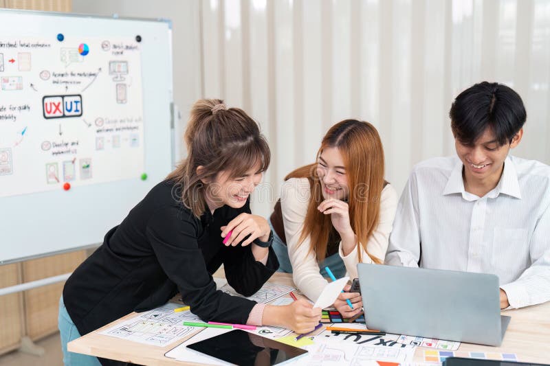Engagiertes Designteam und kreative Ideen. Drei Designer teilen Lachen und Brainstorm während eines lebendigen UX-UI-Projekts. In einer lebendigen Umgebung arbeiten Designer an UX-Projekten der Benutzeroberfläche zusammen, um ihre Ideen vorzustellen und dabei freundschaftliche Interaktionen zu unternehmen, die eine innovative Atmosphäre fördern.