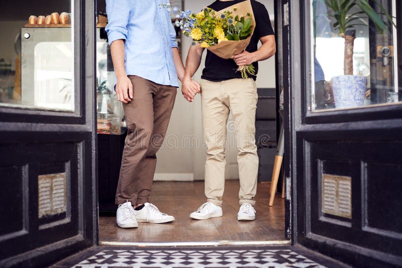 Enge Händen von liebenden männlichen Schwulenschweinen aus Floristen, die Blumenstrauß halten stockbilder