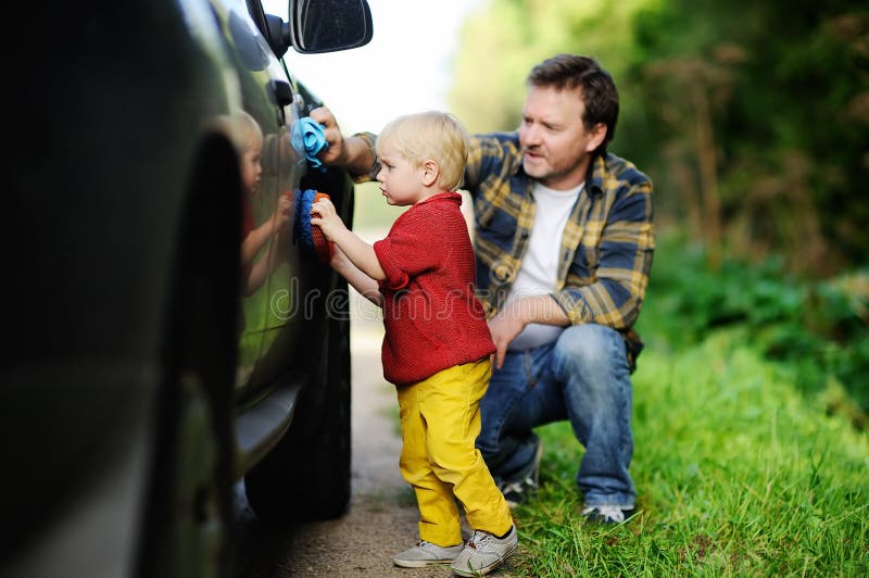 Engendre con su coche que se lava del hijo del niño junto imágenes de archivo libres de regalías Engendre con su coche que se lava del hijo del niño junto imágenes de archivo libres de regalías