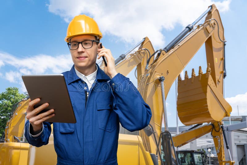 Engenheiro de capacete com tablet digital e telefone imagens de stock royalty free