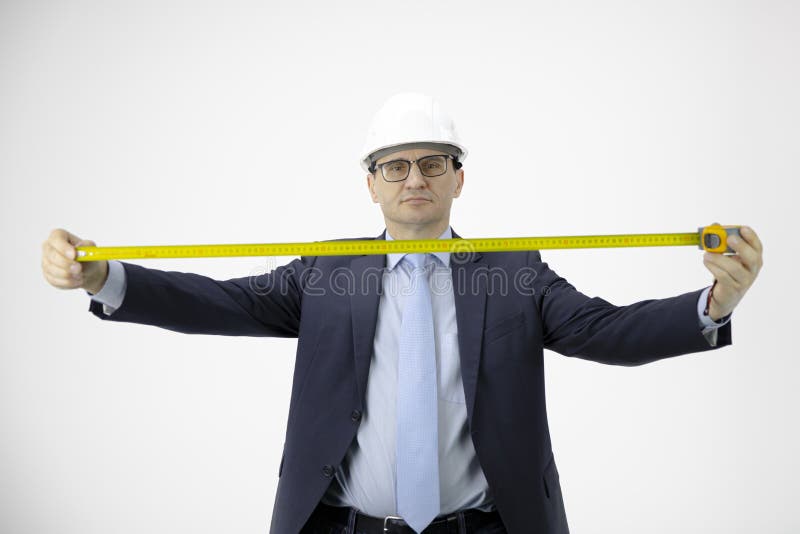 Handsome construction engineer in hard hat holds measuring tape looks at camera isolated on white background. Successful. Handsome construction engineer in hard hat holds measuring tape looks at camera isolated on white background. Successful