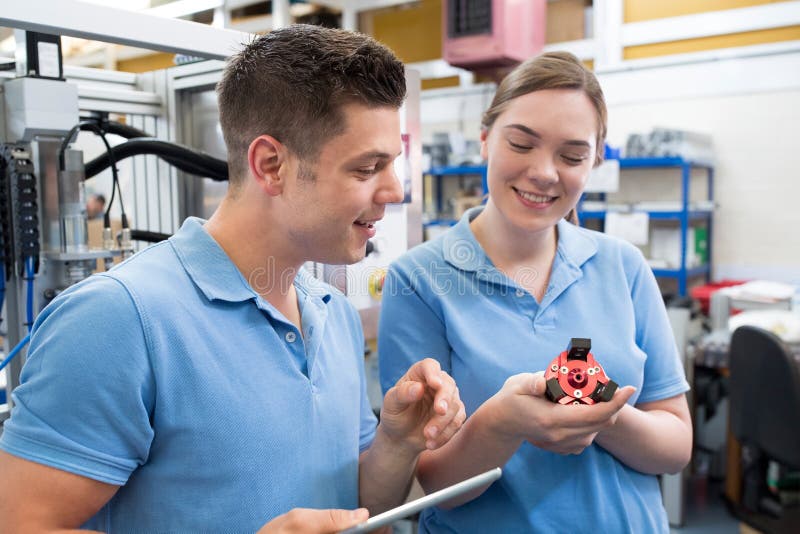 Engineer And Apprentice Examining Component In Factory royalty free stock photo