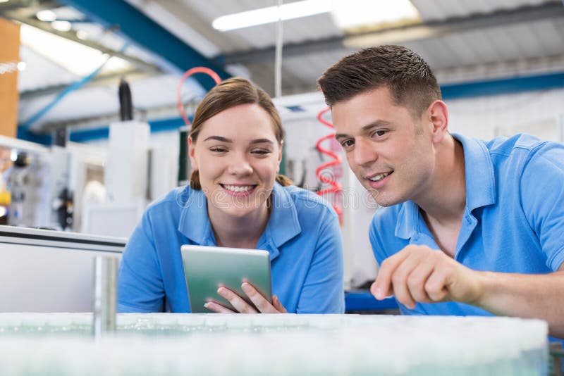 Engineer And Apprentice With Digital Tablet Working In Bottle Ca royalty free stock photos