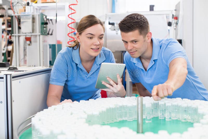 Engineer And Apprentice With Digital Tablet Working In Bottle Ca royalty free stock photos