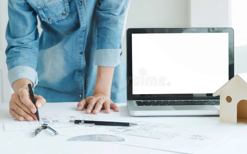 Engineer architects discussing on the table with blueprint with blank screen laptop royalty free stock photo Engineer architects discussing on the table with blueprint with blank screen laptop royalty free stock photo