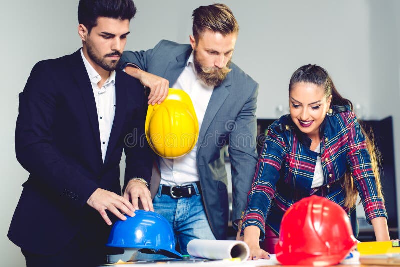 Engineer Architects office team working and discussing house plan with blueprints and house model stock photography Engineer Architects office team working and discussing house plan with blueprints and house model stock photography