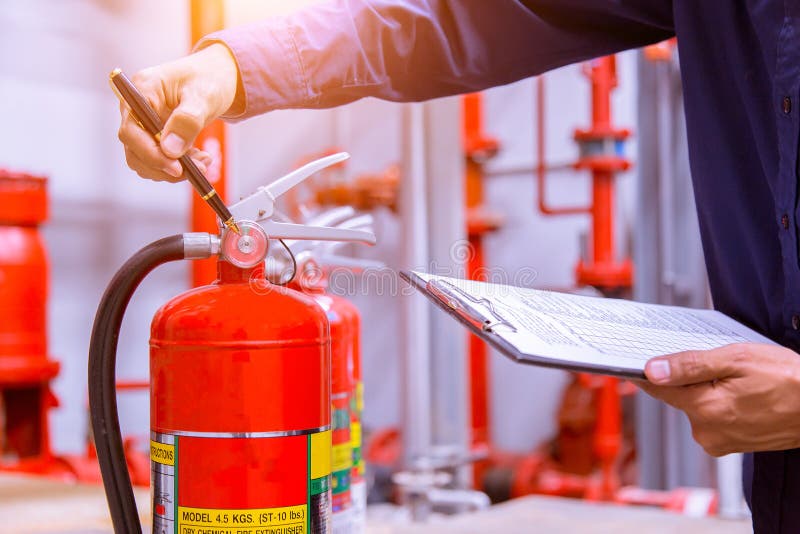 Engineer checking fire extinguisher. stock photography
