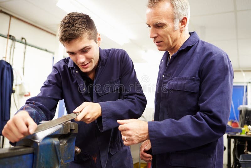 Engineer Checking Trainee's Work On Factory Floor royalty free stock photo Engineer Checking Trainee's Work On Factory Floor royalty free stock photo