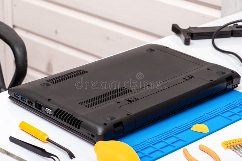 Engineer dismantles the details of a broken laptop for repair stock photos Engineer dismantles the details of a broken laptop for repair stock photos