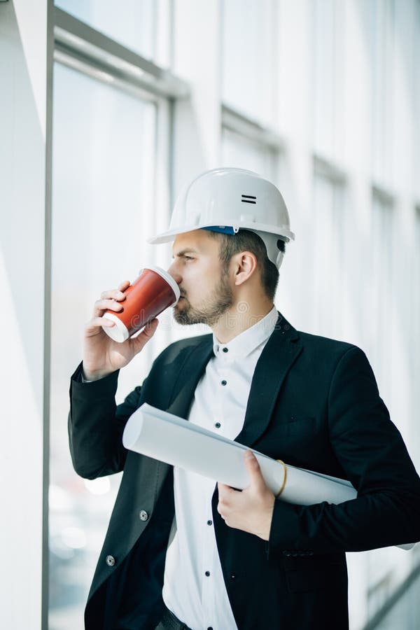 Engineer Drink Coffee with Blueprint in Hands before Inspection of
