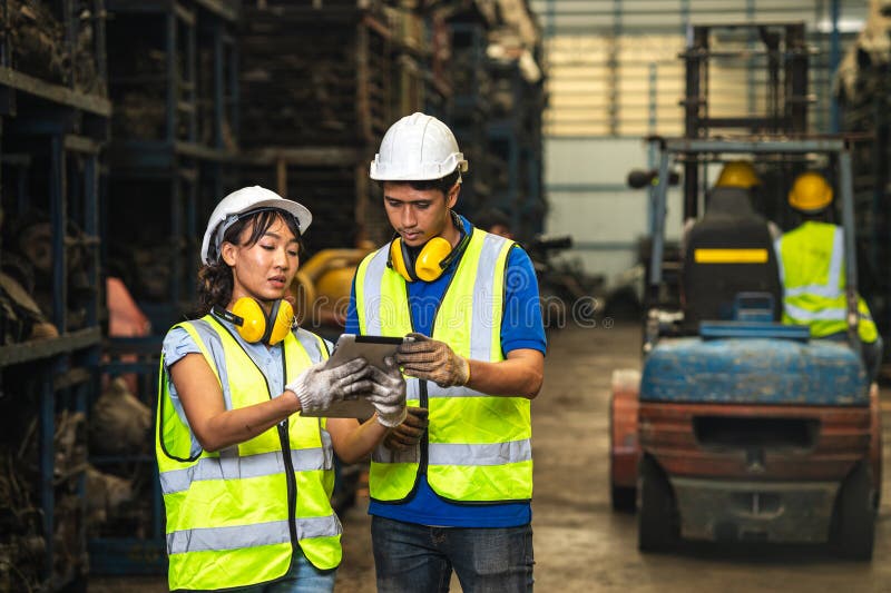 Engineer employee team women worker working together with man work in dirty junkyard old used auto car part warehouse for recycle royalty free stock photos