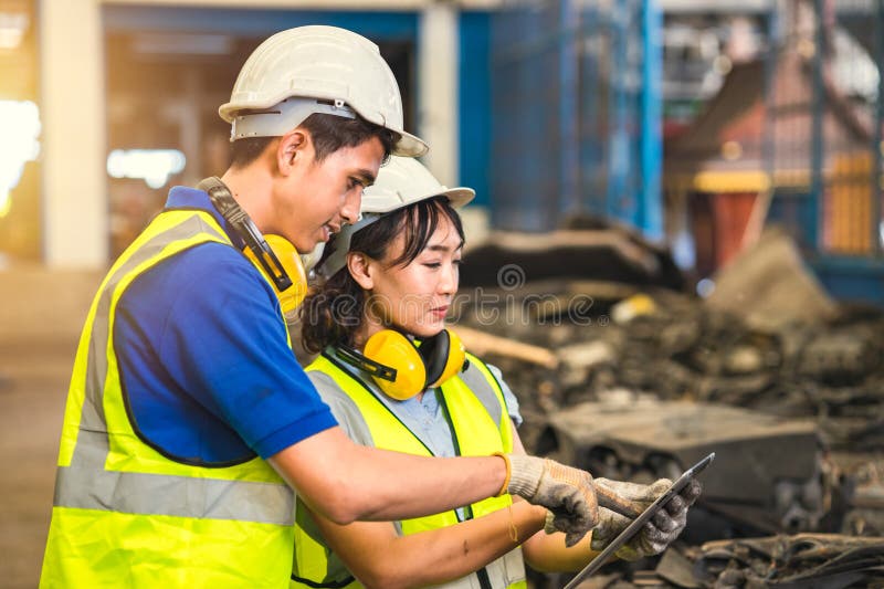 Engineer employee team women worker working together with man work in dirty junkyard old used auto car part warehouse for recycle royalty free stock images