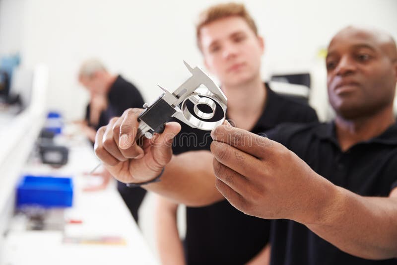 Engineer In Factory With Apprentice Checks Component Quality