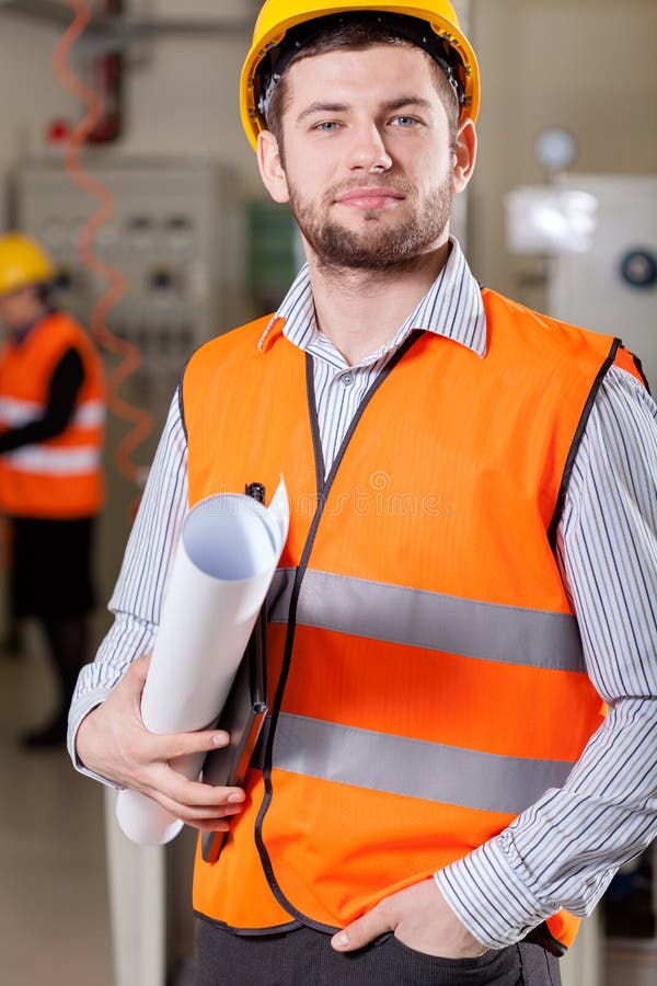 Engineer standing in warehouse, holding his new project, vertical. Standing file folder stock images, royalty-free photos and pictures