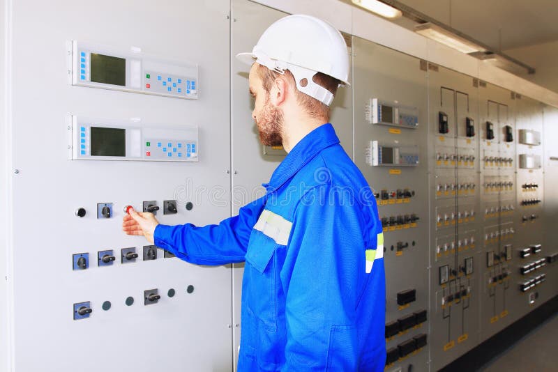 Engineer of an Industrial Power Company in White Helmet Presses Start Button on the Control