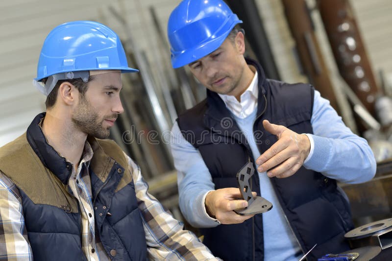 Engineer with mechanical worker checking on quality products