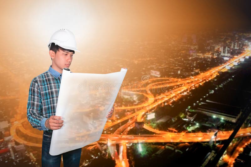 Engineer open hold blueprints in construction concept with night city Blurred background royalty free stock image